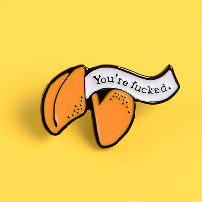 Enamel pin with cartoon fortune cookie dripping oil — in use